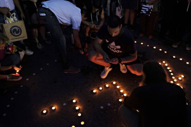 İnsanlar Yunan parliame önünde bir mum ışığı nöbeti katılmak