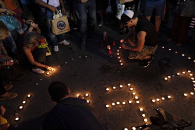 İnsanlar Yunan parliame önünde bir mum ışığı nöbeti katılmak