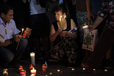 İnsanlar Yunan parliame önünde bir mum ışığı nöbeti katılmak