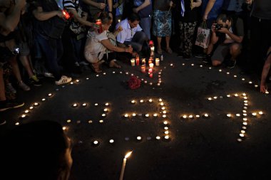 İnsanlar Yunan parliame önünde bir mum ışığı nöbeti katılmak