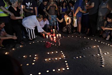 İnsanlar Yunan parliame önünde bir mum ışığı nöbeti katılmak