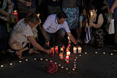 İnsanlar Yunan parliame önünde bir mum ışığı nöbeti katılmak