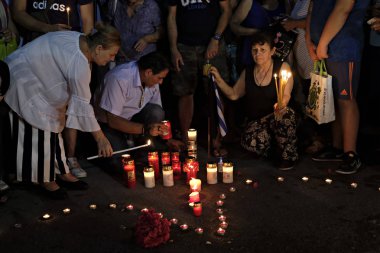 İnsanlar Yunan parliame önünde bir mum ışığı nöbeti katılmak