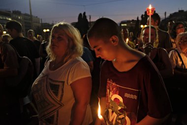İnsanlar Yunan parliame önünde bir mum ışığı nöbeti katılmak