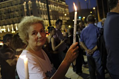 İnsanlar Yunan parliame önünde bir mum ışığı nöbeti katılmak