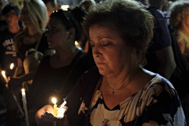 İnsanlar Yunan parliame önünde bir mum ışığı nöbeti katılmak