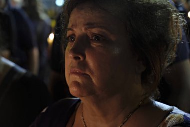 İnsanlar Yunan parliame önünde bir mum ışığı nöbeti katılmak