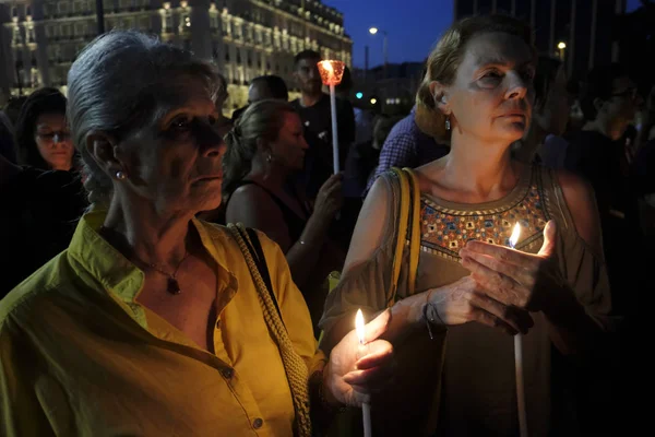 La gente assiste ad una veglia a lume di candela davanti al parlamento greco — Foto Stock