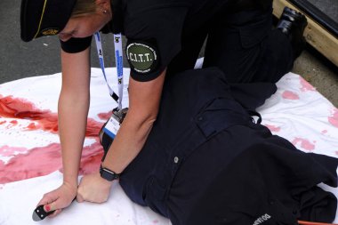 Bir polis, Brüksel 'de bir gösteri sırasında teknik kullanım turnike stop kanama kolu açıklar, Belçika 21 Temmuz 2019.