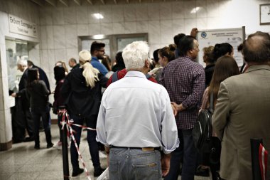 İnsanlar Atina 'da yeraltı Tren İstasyonu platformunda metro bilet doğrulama makineleri arasında yürümek, Yunanistan Ekim 30, 2017