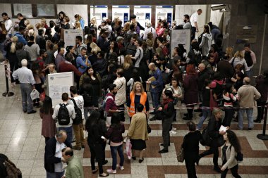 İnsanlar Atina 'da yeraltı Tren İstasyonu platformunda metro bilet doğrulama makineleri arasında yürümek, Yunanistan Ekim 30, 2017