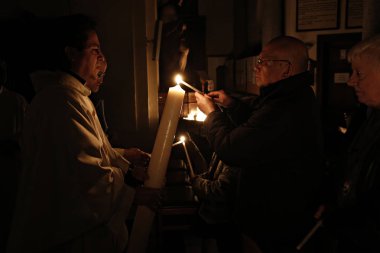 Brüksel, Belçika. 27 Mart 2016. İbadet edenler St Catherine Kilisesi'nde bir Paskalya ayini sırasında mum tutun . 