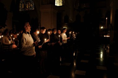 Brüksel, Belçika. 27 Mart 2016. İbadet edenler St Catherine Kilisesi'nde bir Paskalya ayini sırasında mum tutun . 