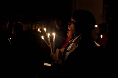 Brüksel, Belçika. 27 Mart 2016. İbadet edenler St Catherine Kilisesi'nde bir Paskalya ayini sırasında mum tutun . 