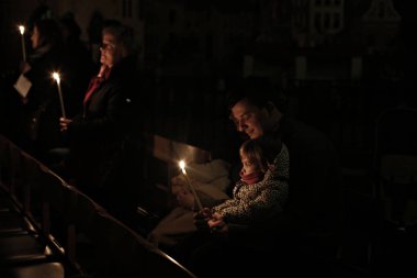 Brüksel, Belçika. 27 Mart 2016. İbadet edenler St Catherine Kilisesi'nde bir Paskalya ayini sırasında mum tutun . 