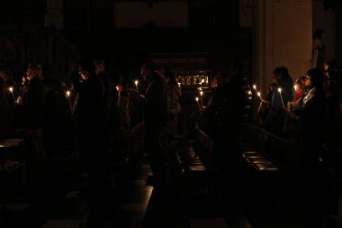 Brüksel, Belçika. 27 Mart 2016. İbadet edenler St Catherine Kilisesi'nde bir Paskalya ayini sırasında mum tutun . 