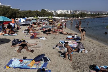 İnsanlar Agia Marina sahilde güneşli havanın tadını çıkarın, Yunanistan, Ağustos 1, 2015.