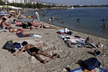 İnsanlar Agia Marina sahilde güneşli havanın tadını çıkarın, Yunanistan, Ağustos 1, 2015.