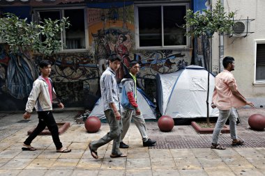 Göçmenler, Atina 'da Victoria Meydanı 'nda bir yağmur fırtınası sırasında kendilerini barınmaya çalışın, Yunanistan Eylül 22, 2015.