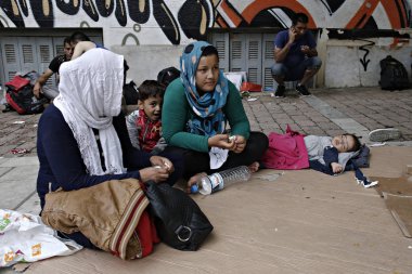 Göçmenler, Atina 'da Victoria Meydanı 'nda bir yağmur fırtınası sırasında kendilerini barınmaya çalışın, Yunanistan Eylül 22, 2015.