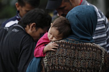 Göçmenler, Atina 'da Victoria Meydanı 'nda bir yağmur fırtınası sırasında kendilerini barınmaya çalışın, Yunanistan Eylül 22, 2015.