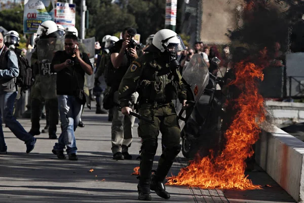 Atina, Yunanistan, 2 Decemeber 2015 hükümetin tasarruf politikası karşı 24 saat genel grev sırasında protestocular ile çatışmalar sırasında isyan polisi bir benzin bombası patlar.