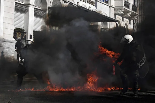 Atina, Yunanistan, 2 Decemeber 2015 hükümetin tasarruf politikası karşı 24 saat genel grev sırasında protestocular ile çatışmalar sırasında isyan polisi bir benzin bombası patlar.