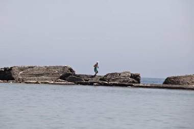 İnsanlar Temmuz ayında Atina Yunanistan 'ın kuzeydoğu banliyölerinde plajları güneşli hava tadını çıkarın. 26, 2015.