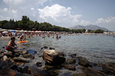 İnsanlar Temmuz ayında Atina Yunanistan 'ın kuzeydoğu banliyölerinde plajları güneşli hava tadını çıkarın. 26, 2015.