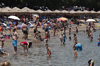 İnsanlar Temmuz ayında Atina Yunanistan 'ın kuzeydoğu banliyölerinde plajları güneşli hava tadını çıkarın. 26, 2015.