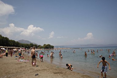 İnsanlar Temmuz ayında Atina Yunanistan 'ın kuzeydoğu banliyölerinde plajları güneşli hava tadını çıkarın. 26, 2015.