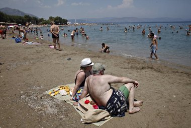 İnsanlar Temmuz ayında Atina Yunanistan 'ın kuzeydoğu banliyölerinde plajları güneşli hava tadını çıkarın. 26, 2015.