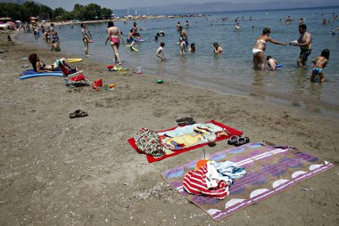 İnsanlar Temmuz ayında Atina Yunanistan 'ın kuzeydoğu banliyölerinde plajları güneşli hava tadını çıkarın. 26, 2015.