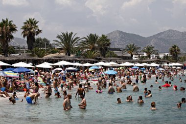 İnsanlar Temmuz ayında Atina Yunanistan 'ın kuzeydoğu banliyölerinde plajları güneşli hava tadını çıkarın. 26, 2015.