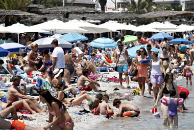 İnsanlar Temmuz ayında Atina Yunanistan 'ın kuzeydoğu banliyölerinde plajları güneşli hava tadını çıkarın. 26, 2015.