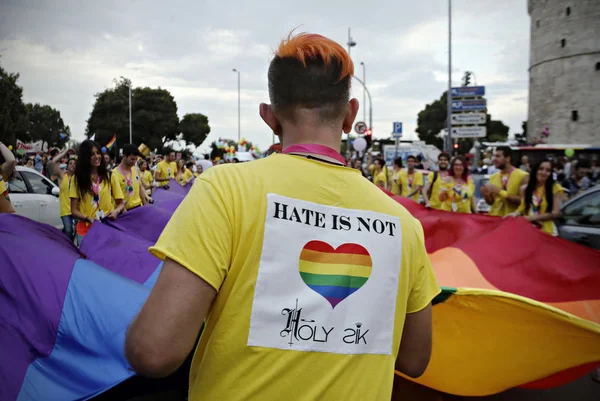 参加者は 2015年6月20日にギリシャのテッサロニキで行われたゲイプライドパレードで行進する際に虹の旗を掲げます — ストック写真