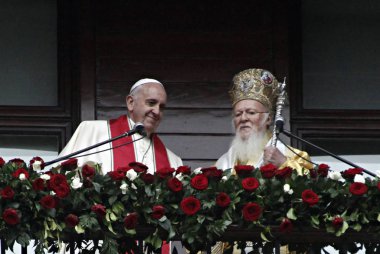 Papa Francis, sol, ve Ecumenical Patriği Bartholomew ben ellerini tutmak ve Istanbul 'da St George Patriarchal Kilisesi Kutsal bir ayin sonra sadık dalga, Pazar, Kasım 30, 2014. 