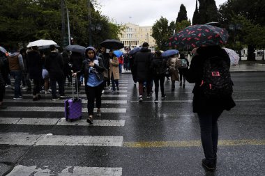 Yayalar, Atina 'da yağış sırasında şemsiyeler ile yağmur kendilerini korumak, Yunanistan 4 Nisan, 2019