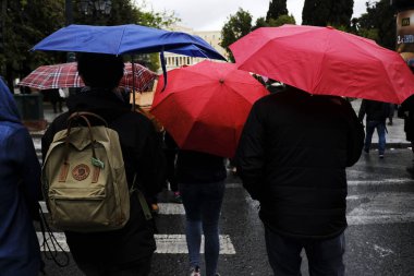 Yayalar, Atina 'da yağış sırasında şemsiyeler ile yağmur kendilerini korumak, Yunanistan 4 Nisan, 2019