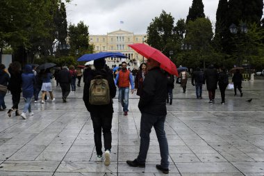 Yayalar, Atina 'da yağış sırasında şemsiyeler ile yağmur kendilerini korumak, Yunanistan 4 Nisan, 2019