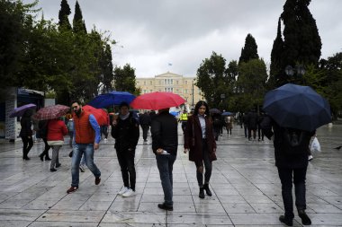 Yayalar, Atina 'da yağış sırasında şemsiyeler ile yağmur kendilerini korumak, Yunanistan 4 Nisan, 2019