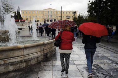 Yayalar, Atina 'da yağış sırasında şemsiyeler ile yağmur kendilerini korumak, Yunanistan 4 Nisan, 2019