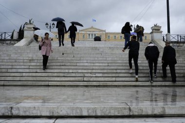 Yayalar, Atina 'da yağış sırasında şemsiyeler ile yağmur kendilerini korumak, Yunanistan 4 Nisan, 2019