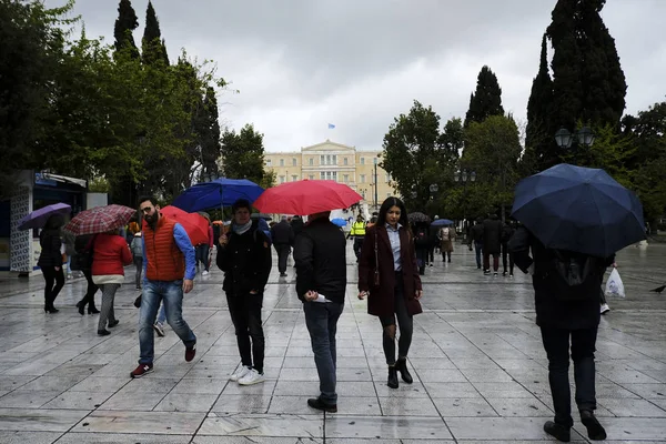 Yayalar, Atina 'da yağış sırasında şemsiyeler ile yağmur kendilerini korumak, Yunanistan 4 Nisan, 2019