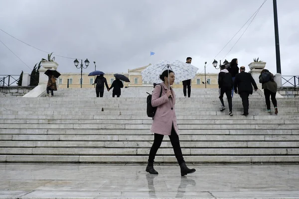 Yayalar, Atina 'da yağış sırasında şemsiyeler ile yağmur kendilerini korumak, Yunanistan 4 Nisan, 2019