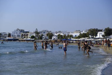 İnsanlar güneşli hava onlar, 2018 Ağustos 'ta Yunanistan Naxos adasında Agios Georgios plajında denize yüzme gibi zevk