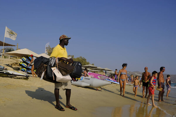 Уличный торговец продает солнцезащитные очки на пляже деревни Агиос Прокопиос в Наксосе, Греция 19 августа 2018 года
