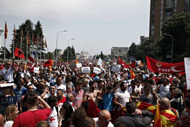 17 Mayıs 2015'te Makedonya'nın Başkenti Üsküp'te hükümet dairelerine doğru yürüyen Başbakan Nikola Gruevski'ye karşı düzenlenen protesto gösterisinde ellerinde Makedon bayrağı ve pankartları bulunan protestocular