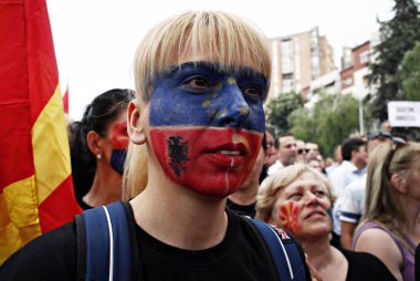 17 Mayıs 2015'te Makedonya'nın Başkenti Üsküp'te hükümet dairelerine doğru yürüyen Başbakan Nikola Gruevski'ye karşı düzenlenen protesto gösterisinde ellerinde Makedon bayrağı ve pankartları bulunan protestocular