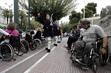 21 Ekim 2015'te Yunanistan'ın başkenti Atina'da yaşanan ekonomik krizde tasarruf tedbirlerine ilişkin korkular üzerine engelliler iş ve diğer haklar talep etmek için protesto gösterisi düzenlediler